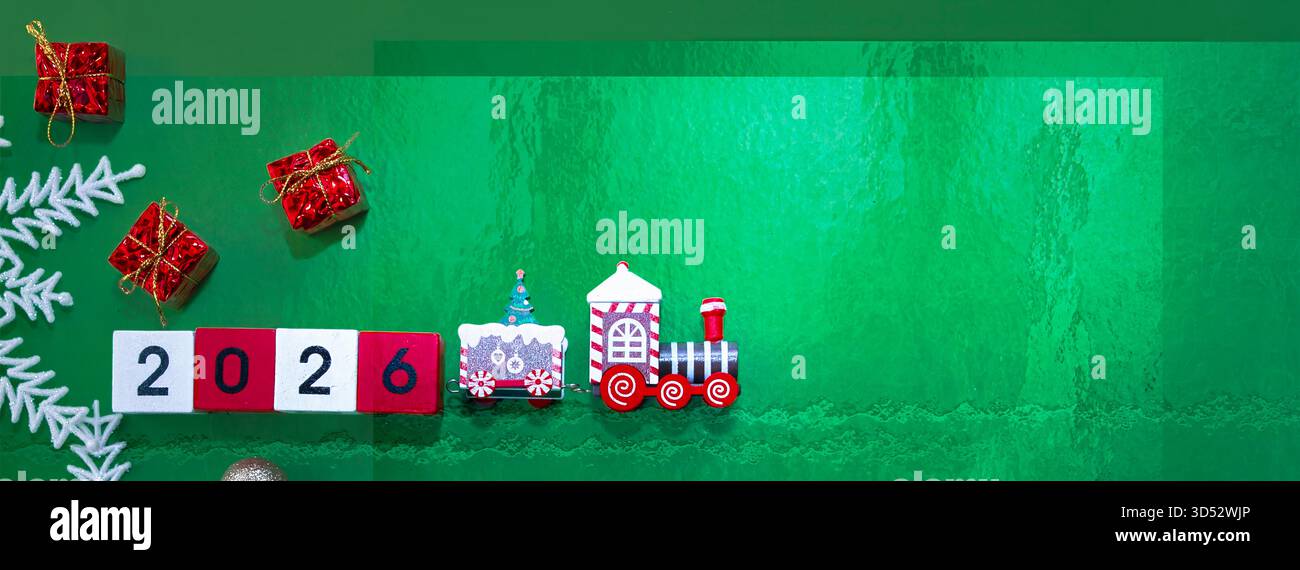 Grüner festlicher Hintergrund mit kleinen Geschenken und hölzernen 2026 Nummernblöcken Stockfoto