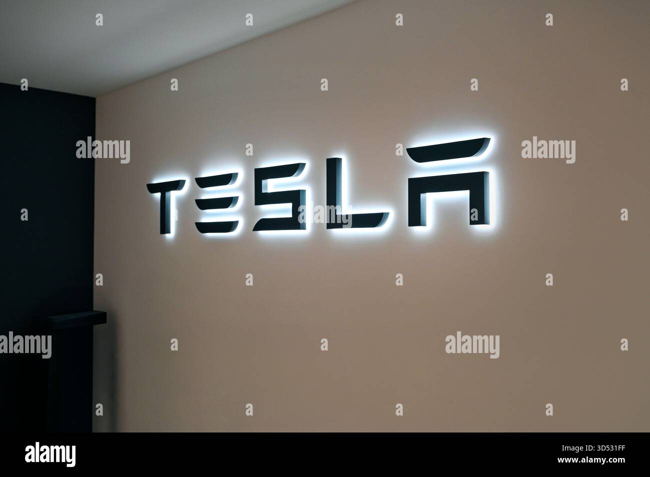 GENF - 14. Oktober: TESLA-Logo an der Wand im Ausstellungsraum des Autos am 14. Oktober. 2025 in der Schweiz Stockfoto