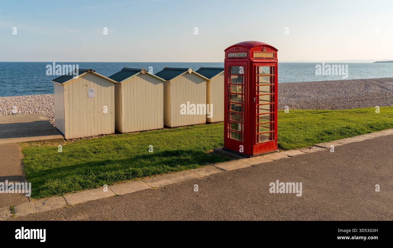Strandhütten und Telefonzelle in der Nähe von Den Kiesstrand, Budleigh Salterton, Jurassic Coast, Devon, Großbritannien Stockfoto