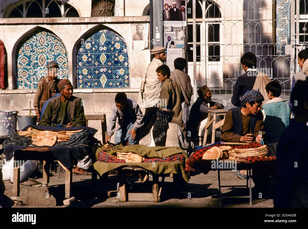 Brotverkäufer auf einem Kabul Straßenmarkt, Afghanistan, 1992, mit gemusterten Fliesen und Menschen in traditioneller Kleidung. Stockfoto