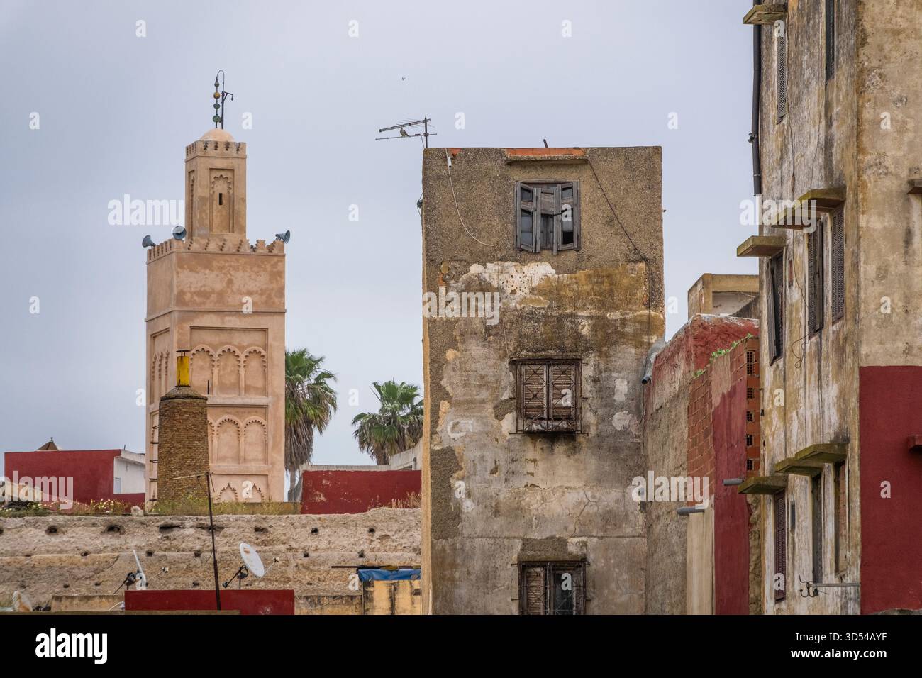 Rabat, Marokko – Blick auf die traditionellen Gebäude in der alten Medina mit einem historischen Moschee-Minarett im Hintergrund. Die verwitterten Wände aus Holz Stockfoto