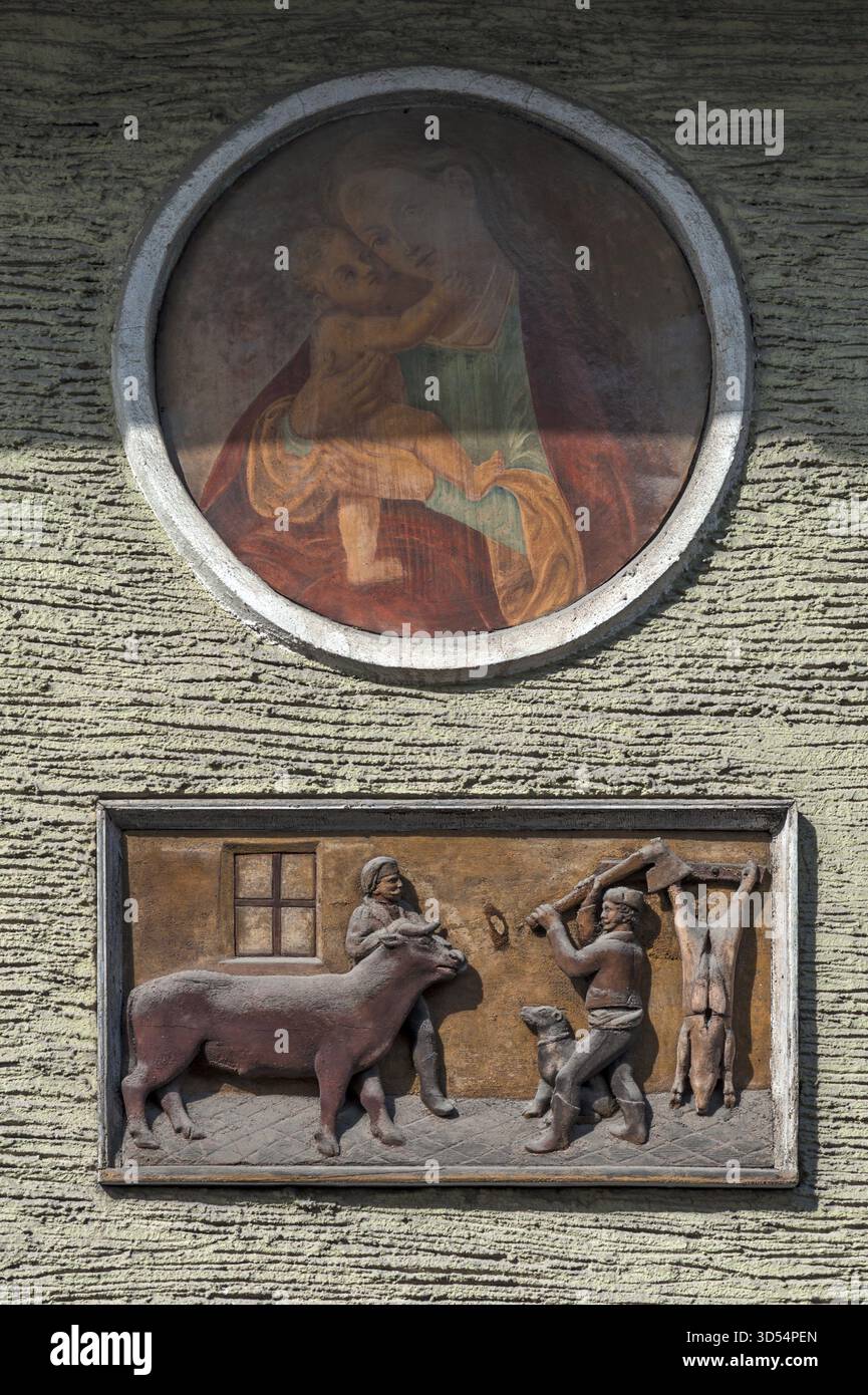 Relief-Darstellung eines Hausschlachtes über einem heiligen in einem Stadthaus, Going am Wilden Kaiser, Tirol, Österreich Stockfoto