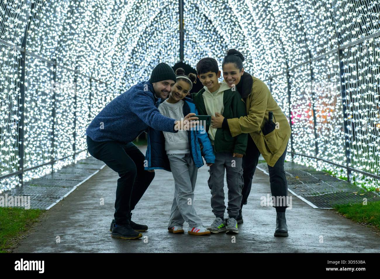 13/11/2025. Besucher von London, Großbritannien, genießen die Weihnachtsbeleuchtung, die als Teil des ursprünglichen festlichen Weges durch die herrliche Landschaft der Kew Royal Botanical Gardens nach der Dunkelheit gezeigt wird, und kehren zum dreizehnten Jahr mit einer Vielzahl von saisonalen Favoriten zusammen mit faszinierenden neuen Lichtinstallationen zurück. Acht Installationen geben ihr Debüt in Großbritannien. Kews natürliche Architektur ist beleuchtet, sodass Besucher die Natur aus einer neuen Perspektive erleben können Weihnachten in Kew ist ein Ausflug für Besucher jeden Alters, vom Freitag, den 14. November 2025 bis Sonntag, den 4. Januar 2026. Foto: Ray Tang Stockfoto
