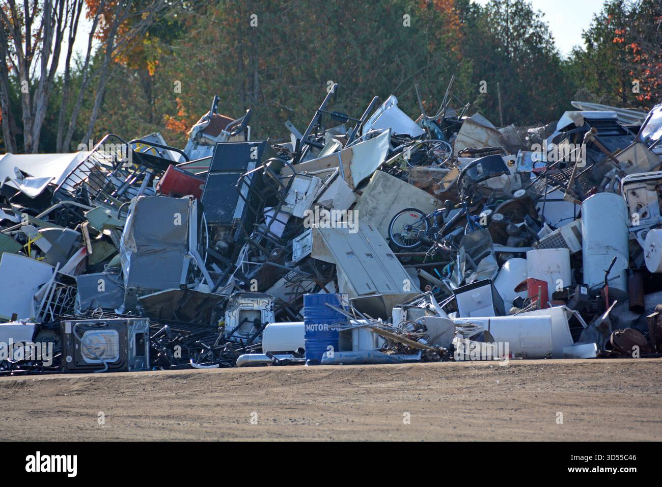 Ein großer Stapel verdrehter Metallteile und zerbrochener Gegenstände, die darauf warten, getrennt und recycelt zu werden. Stockfoto