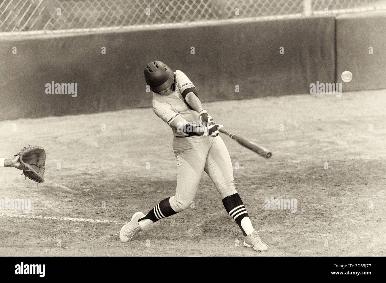 Ein Baseballspieler wird in Full-Motion-Action mit antikem Grainy Schwarz und weiß als Swinging the Fledermaus gefangen Stockfoto