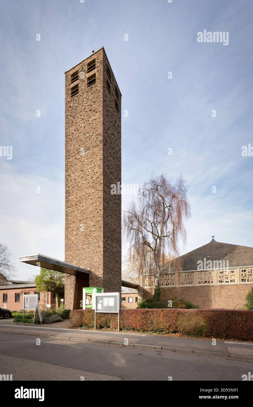 Markanter vertikaler Blick auf die moderne Evangelische Kirche (1967) in Brauweiler, mit einem hohen, brutalistischen Backsteinglockenturm und einem gemusterten Wal Stockfoto