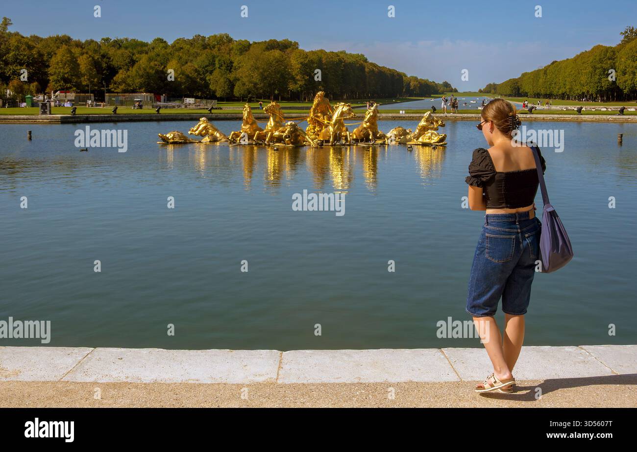 Frau am Apollo-Brunnen in den Gärten des Schlosses von Versailles, Frankreich Stockfoto