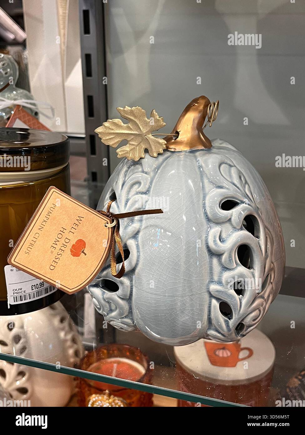 Eine Nahaufnahme eines dekorativen Keramikkürbis mit komplizierten Ausschnitten, ausgestellt in einem Ladenregal in Hull, England. Das Ornament ist glänzend - Smartphone-aufgenommenes Stockfoto