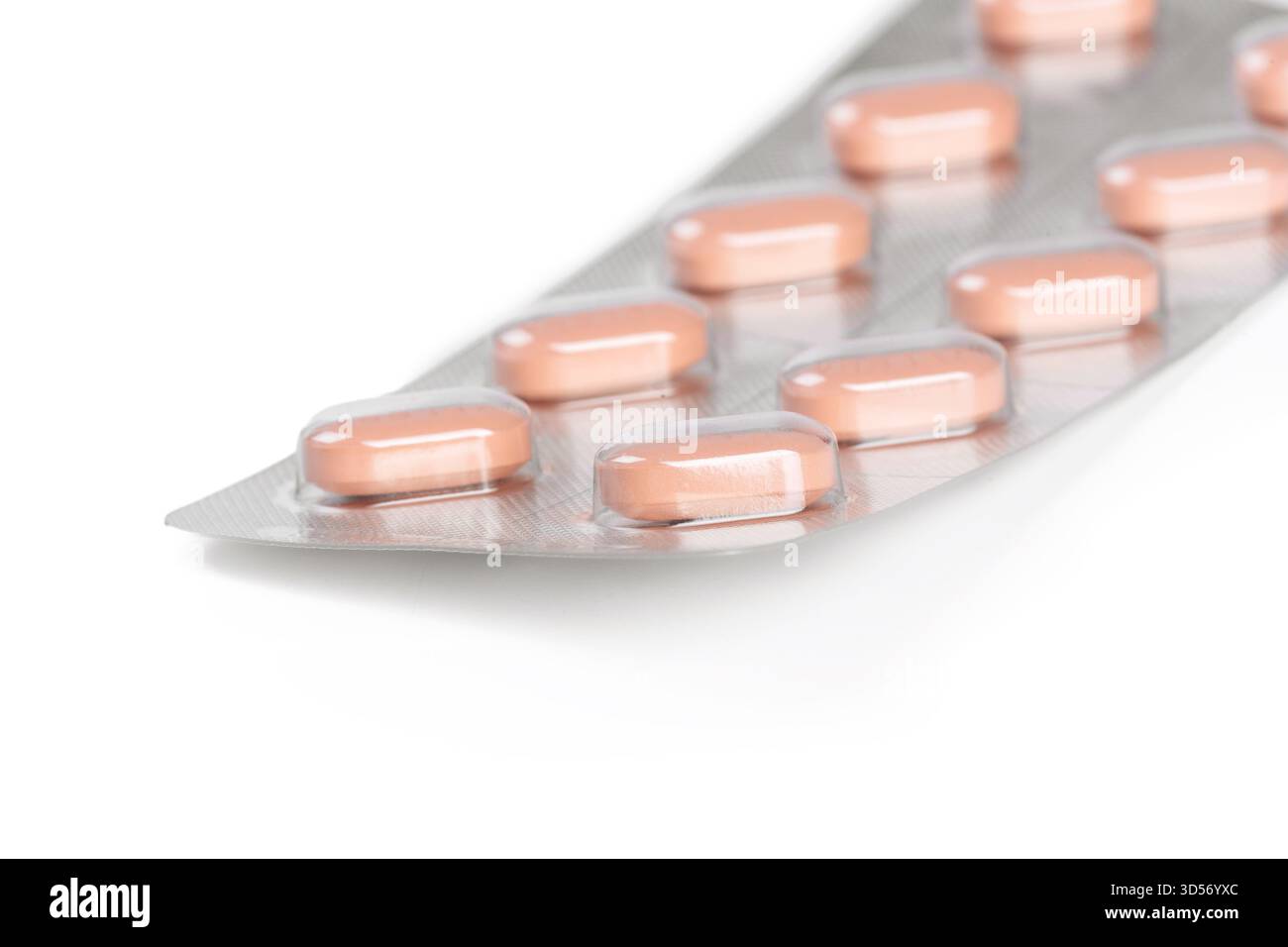 Packung mit rosafarbenen Kapseln in einer Reihe auf einer Folienunterlage angeordnet Stockfoto