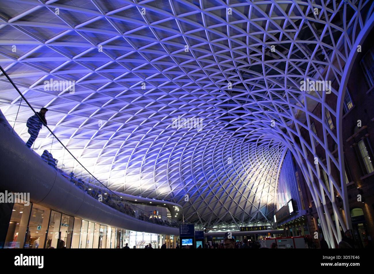 Kings Cross Station Baldachin aus der Station, die nach oben blickt. Mit violetter Beleuchtung und einzelner Silhouette für noch mehr Maßstab Stockfoto