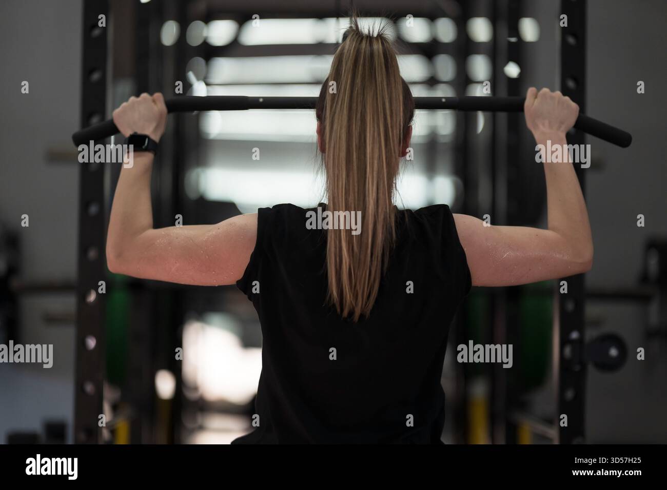 Gewichtheben Frau, die in einem Fitnessstudio trainiert, konzentriert sich auf die Kraft während eines Oberkörpertrainings Stockfoto