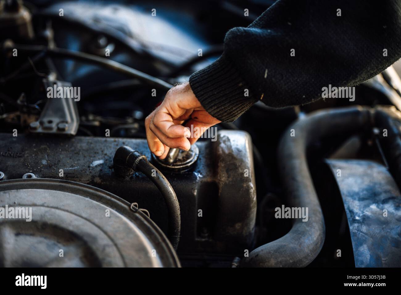 Motorwartung in einer Werkstatt mit einer Hand, die den Ölstand überprüft Stockfoto