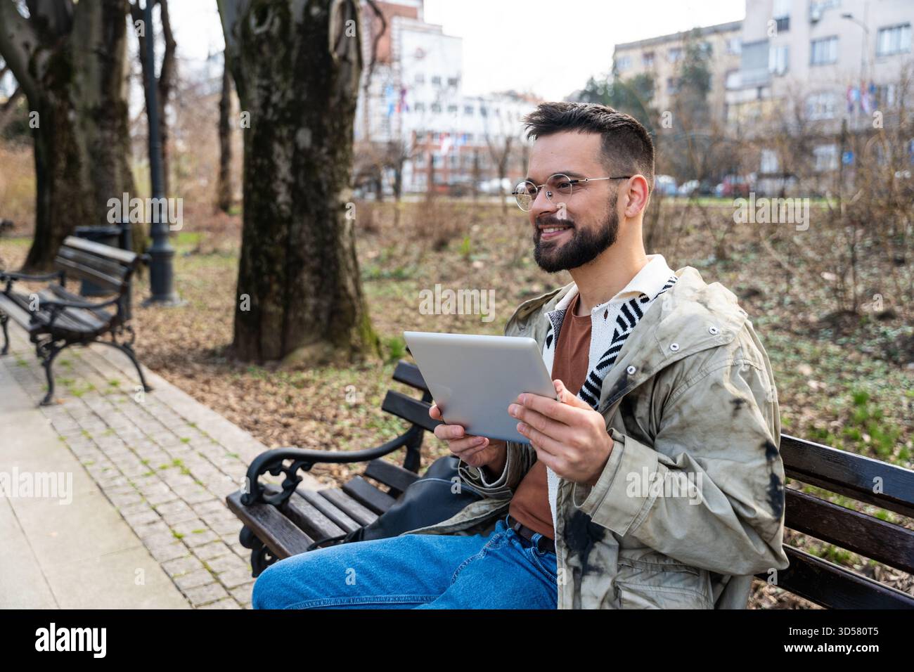 Coole freiberufliche Arbeit vom Parktisch aus mit Tablet, Antworten auf Kunden, Rezensionen, Terminplanung, produktives Arbeiten im Freien Stockfoto