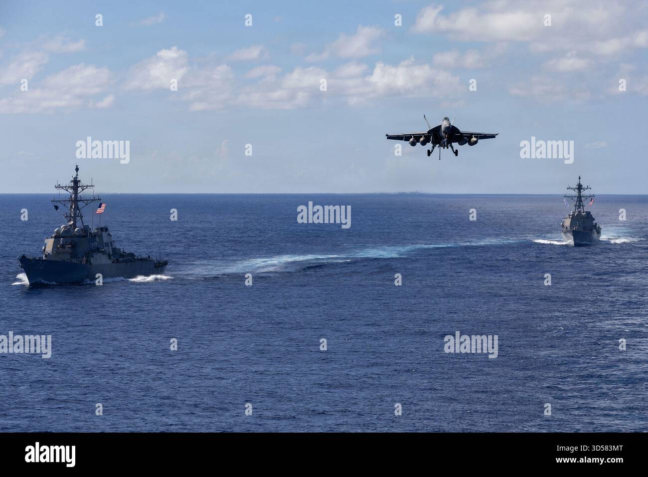 Die Arleigh-Burke-Klasse USS Mahan (DDG 72) und USS Bainbridge (DDG 96) segeln in Formation als F/A-18 Super Hornet, zugeteilt an Carrier Air Wing Acht, an Bord der USS Gerald R. Ford (CVN 78), und steigen am Donnerstag, den 13. November 2025 bei der endgültigen Landung auf dem Flugzeugträger ab. US-Streitkräfte, wie die Gerald R. Ford Carrier Strike Group, werden eingesetzt, um die Mission des US-Südkommandos zu unterstützen, Operationen des Department of war-Directed Operations und die Prioritäten des Präsidenten, den illegalen Drogenhandel zu unterbinden und die Heimat zu schützen. Foto von PO2 Trin Stockfoto