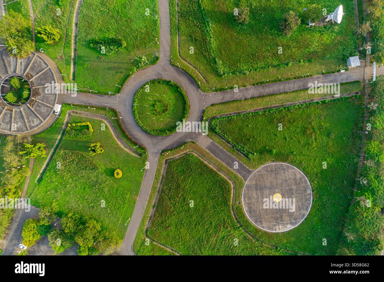 Aus der Vogelperspektive der kreisförmigen Muster und radialen Pfade entsteht ein faszinierender Tanz aus Grün und Beton, der mit den üppigen Landschaften der Umgebung kontrastiert Stockfoto