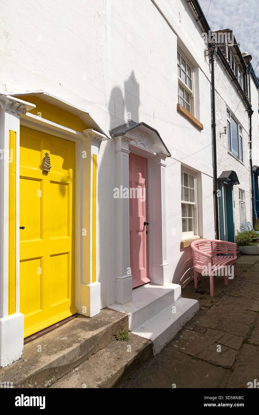 Farbenfrohe Eingangstüren in Robin Hood's Bay in North Yorkshire, England. Sie sind auf weiß gestrichenen Häusern. Stockfoto