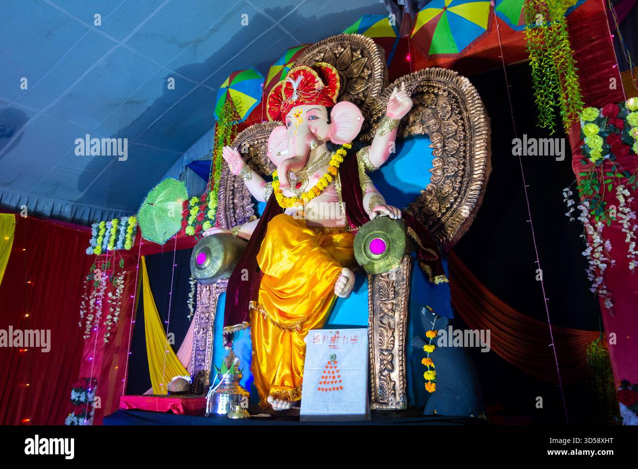 Lord ganesha Idol. Lebendige ganesh Chaturthi-Einrichtung mit bunten Regenschirmen Stockfoto