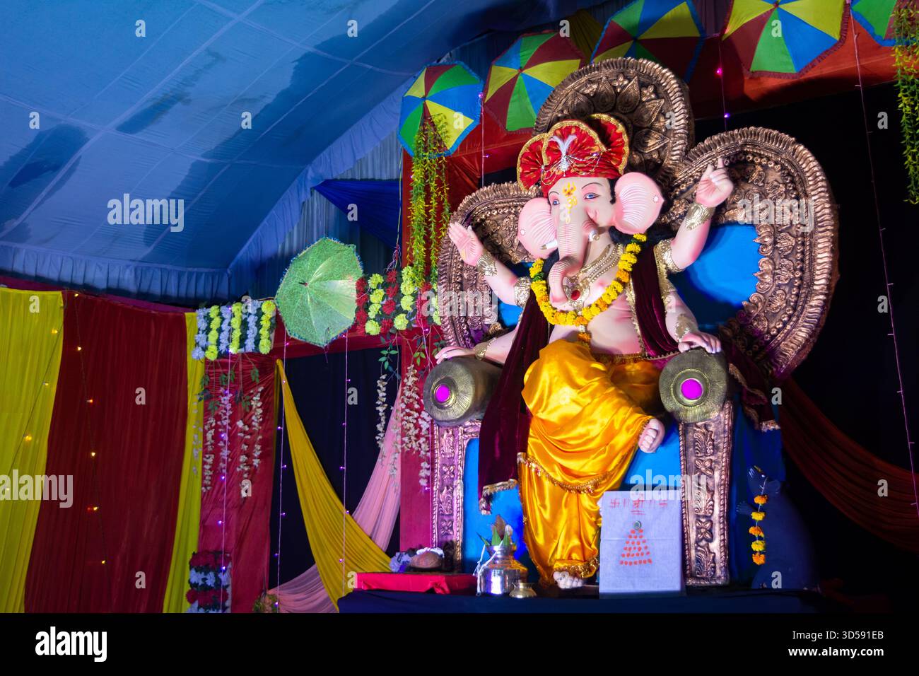 Lord ganesha Idol. Lebendige ganesh Chaturthi-Einrichtung mit bunten Regenschirmen Stockfoto