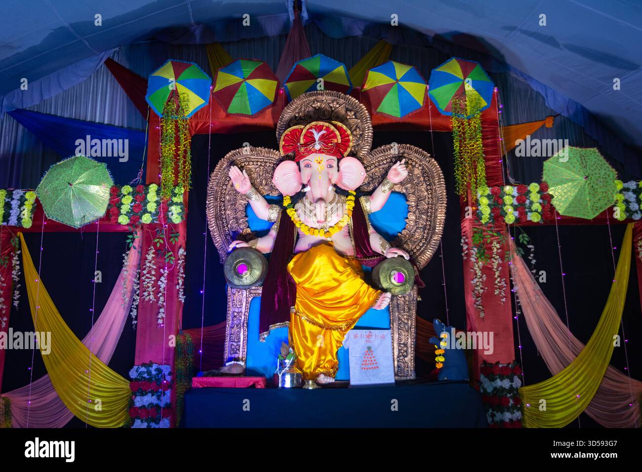 Lord ganesha Idol. Lebendige ganesh Chaturthi-Einrichtung mit bunten Regenschirmen Stockfoto
