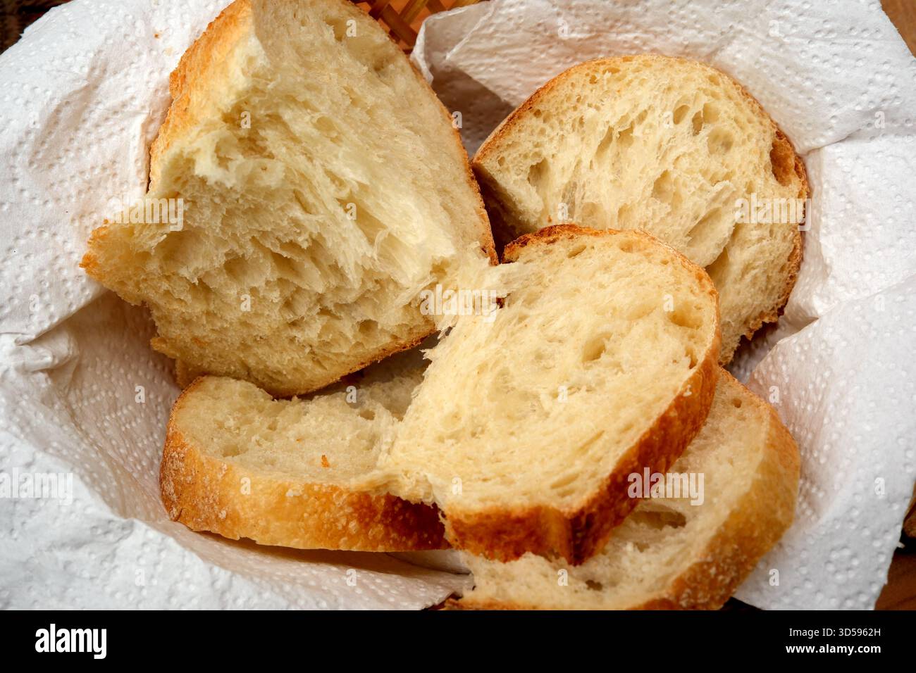 Weiche, flauschige Brotscheiben werden ordentlich in einem Korb angeordnet, um sie zu genießen. Stockfoto