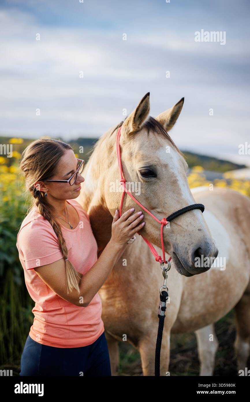 Die Frau streichelt Therapiepferd. Freundschaft zwischen Menschen und Tieren. Pferdeassistierte Therapie auf der Tierhaltung Stockfoto