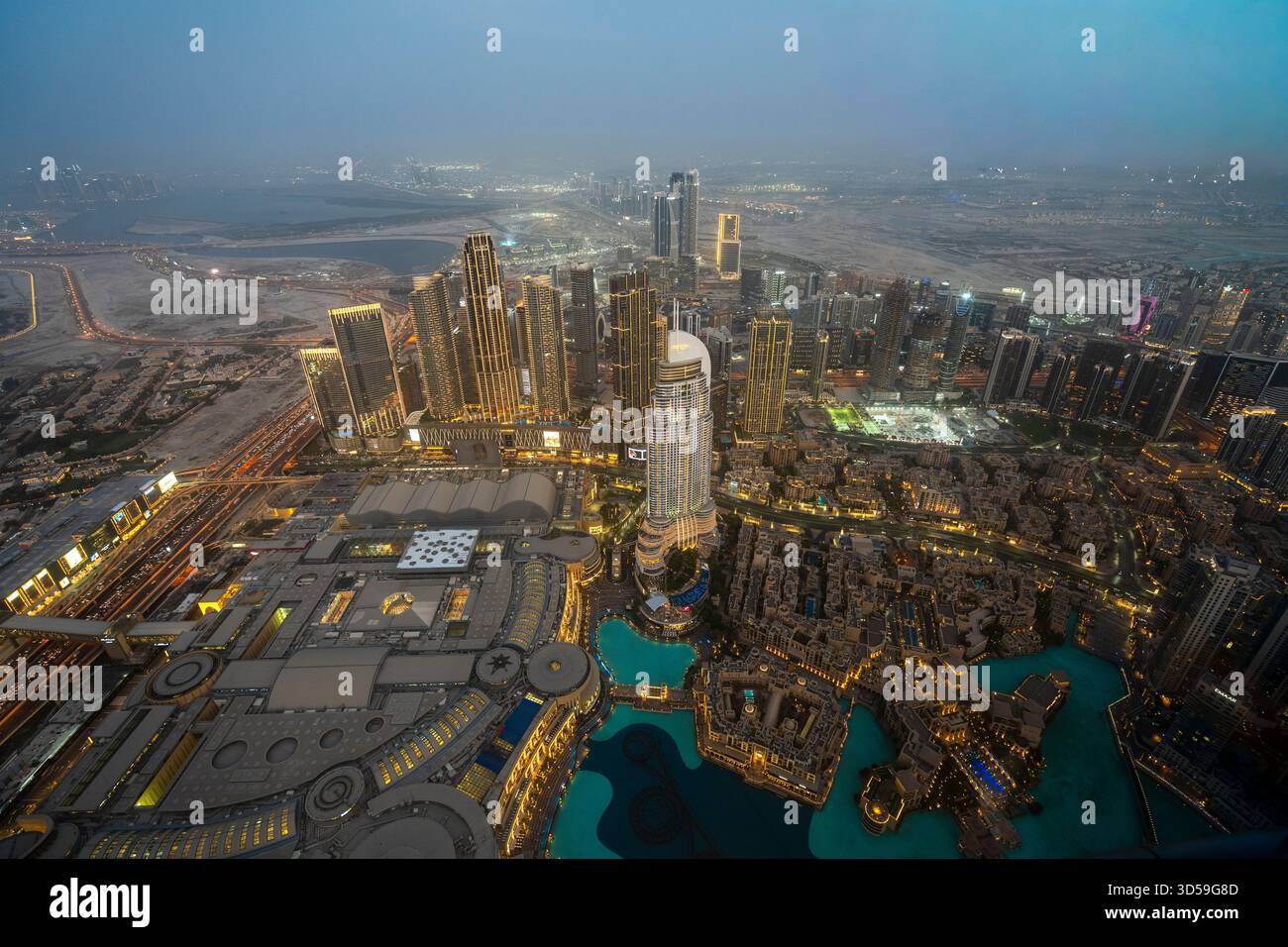 Ein atemberaubender nächtlicher Blick auf Abu Dhabi City von einem der höchsten Türme aus mit glitzernden Wolkenkratzern, beleuchteten Straßen und Reflexionen Stockfoto