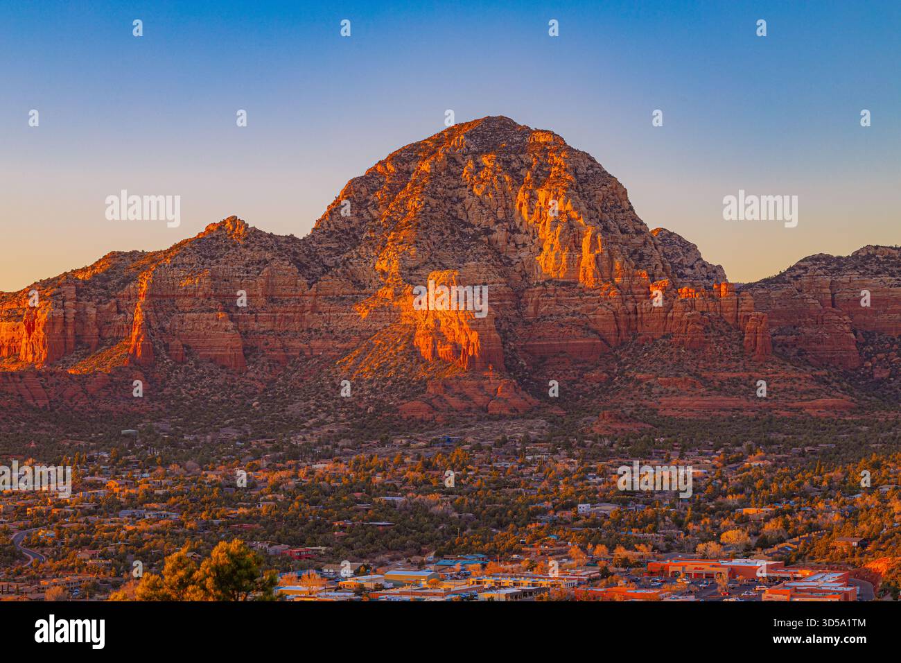 Ein warmer Sonnenuntergang beleuchtet die berühmten roten Felsformationen von Sedona, Arizona. Die leuchtenden Klippen ragen über die Stadt und schaffen eine beeindruckende Landschaft Stockfoto