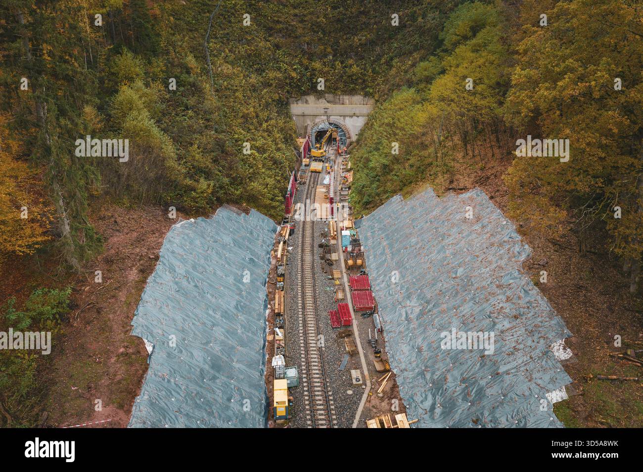 Bahnbau vor einem Tunnel in einem Herbstwald, von oben gesehen, Baustelle Hermann-Hesse-Bahn, Calw, Deutschland Stockfoto