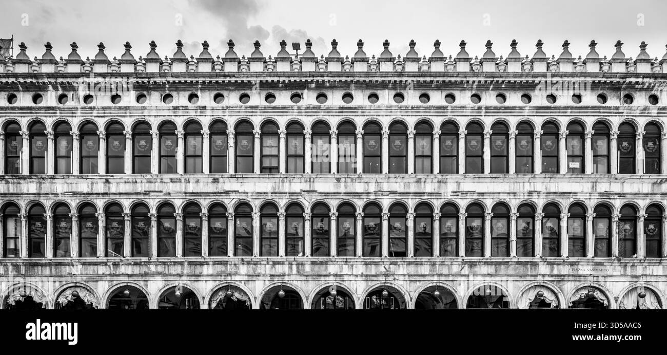 Die Old Procuracies am Saint Marc Square bieten komplexe architektonische Details, die venezianisches Design und Handwerkskunst aus einer vergangenen Zeit vor einem stimmungsvollen Himmel hervorheben. Stockfoto