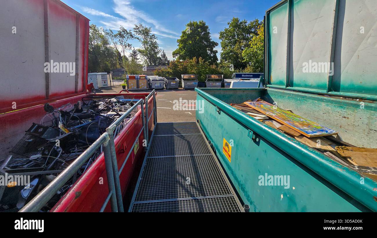 Uhldingen-Muhlhofen, Deutschland - 13. September 2025. Zwei große offene Müllcontainer gefüllt mit verschiedenen Metallschrott, Bauabfällen und altem f Stockfoto