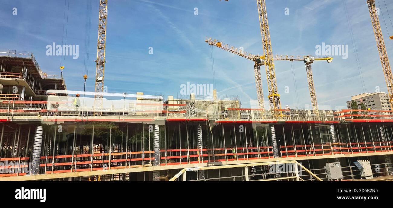 Berlin - 17. Juni 2025: Baustelle mit Kranen und Gerüsten vor klarem blauem Himmel. - Smartphone-aufgenommenes Stockfoto