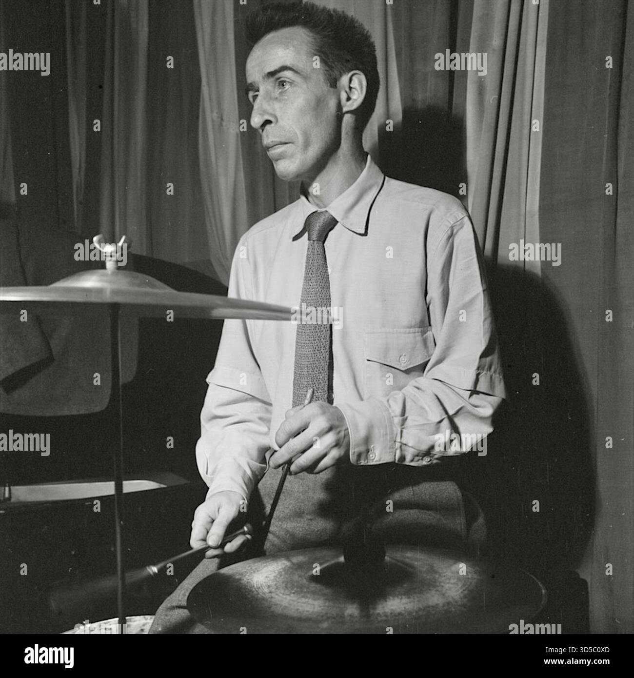 William P. Gottlieb: Dave Tough, ein einflussreicher US-amerikanischer Jazz-Schlagzeuger. In den 1930er und 1940er Jahren war er eine Schlüsselfigur im Dixieland- und Swing-Jazz Tough war bekannt für seinen subtilen, aber intensiven, schwungvollen Stil und seine nahezu perfekte Zeitmessung, die eine tiefe Wirkung auf andere Schlagzeuger hatte. Er spielte selten Schlagzeug-Soli, war aber ein Meister des Ensemblespiels, indem er seine Schlagzeug auf bestimmte Tonhöhen stimmte und das Ride Cymbal zu einem Kernstück seines Sets machte. Tough war Gründungsmitglied der Chicago-Style Jazz-Gruppen und brachte später seine einzigartige Fluidität in zahlreiche Big Bands, vor allem mit Woody Herman. Stockfoto