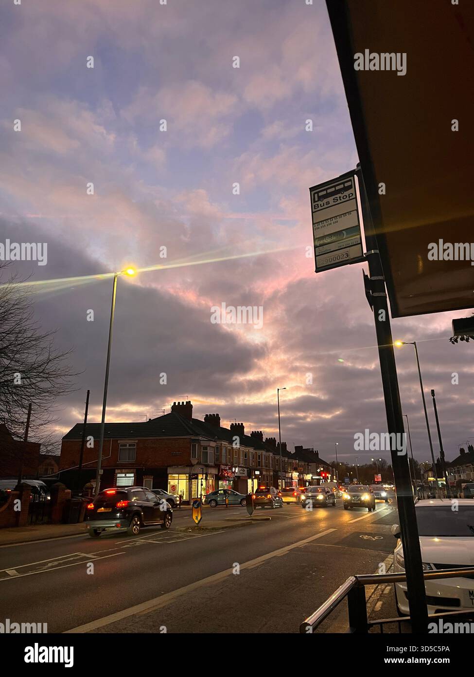 Stadtblick in Leeds, England, während der Dämmerung mit bunten Wolken, Straßenlaternen, Verkehr und klassischen britischen Stadthäusern. - Smartphone-aufgenommenes Stockfoto