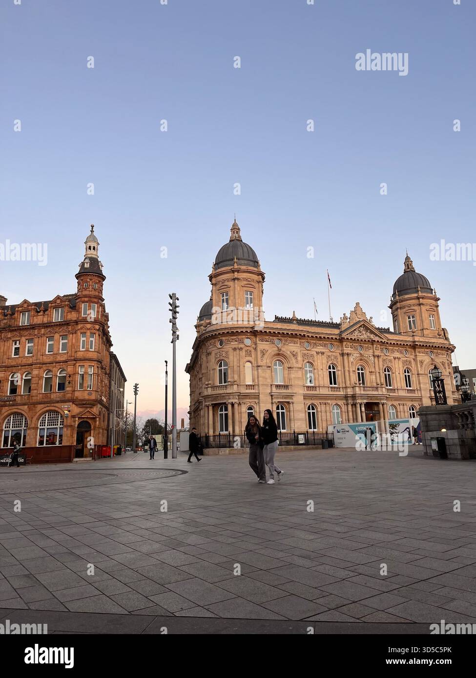 Großer Blick auf einen gepflasterten öffentlichen Platz, umgeben von historischen Gebäuden und verzierten Fassaden im Stadtzentrum von Hull, England unter klarem Himmel. Stockfoto