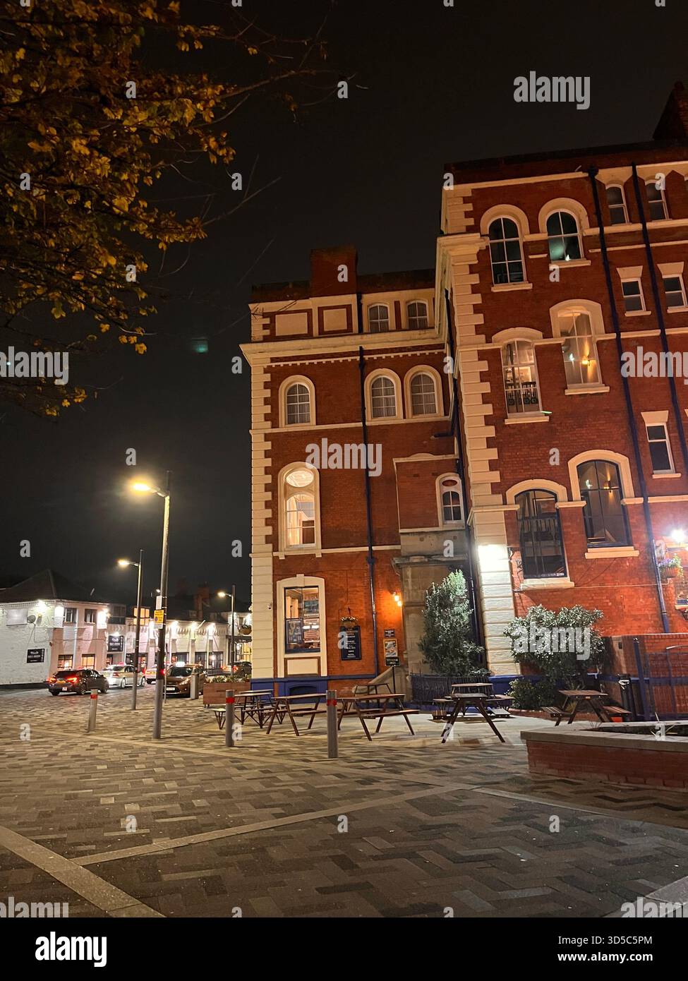 Traditionelles rotes Backsteingebäude mit weißen dekorativen Details, fotografiert bei Nacht im Stadtzentrum von Hull, England, mit Straßenbeleuchtung und leer Stockfoto