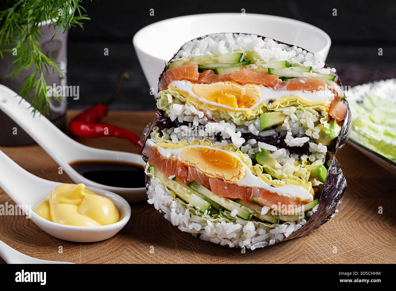 Kreativer Sushi-Burger mit Lachs, Spiegelei, Käse, Gurke und Avocado auf strukturiertem Hintergrund. Stockfoto