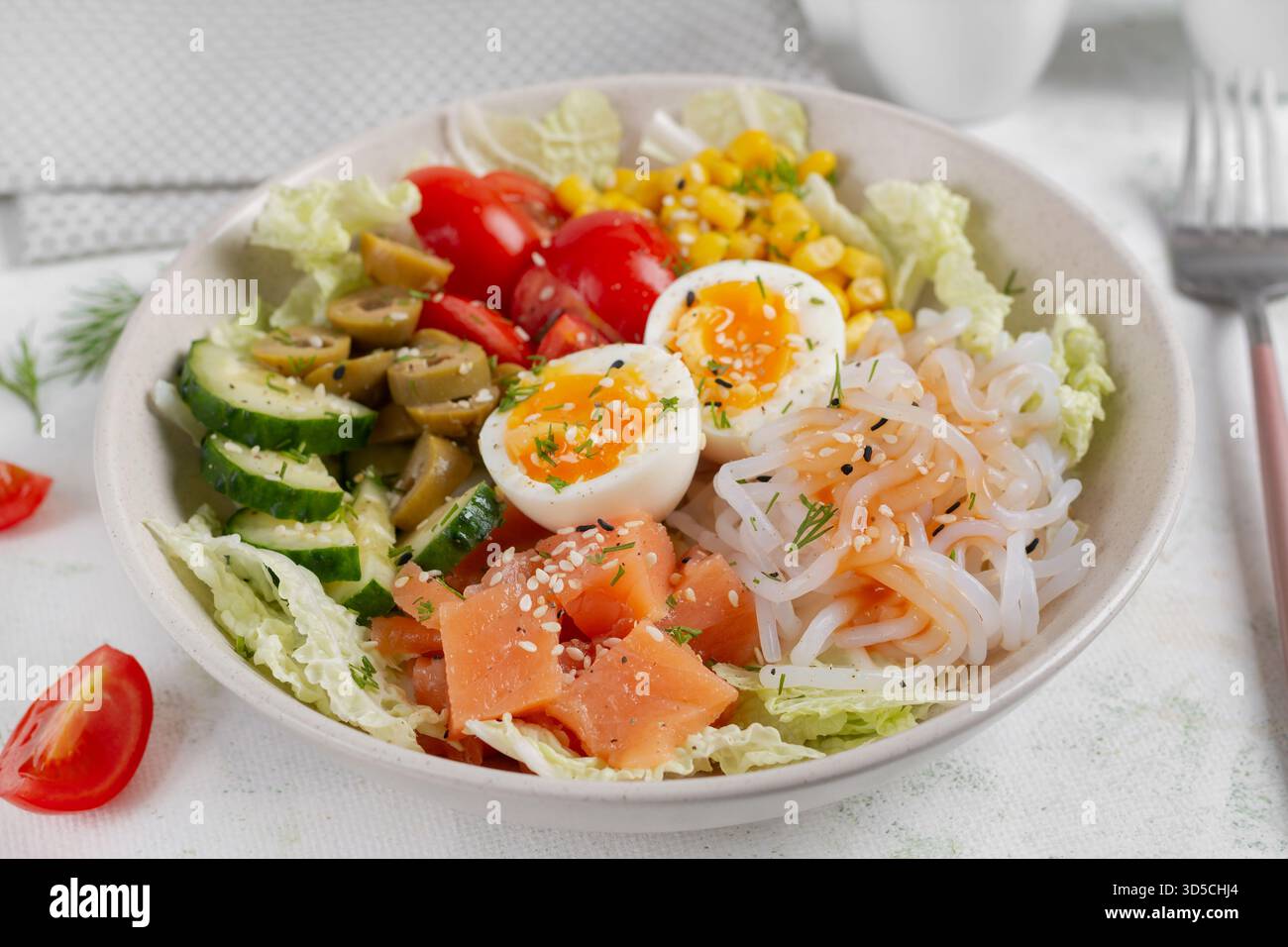 Buddha Schüsseln mit Lachs, gekochtem Ei, Tomaten, Mais, Gurke, Shirataki-Nudeln und Sesam. Asiatische Küche. Stockfoto
