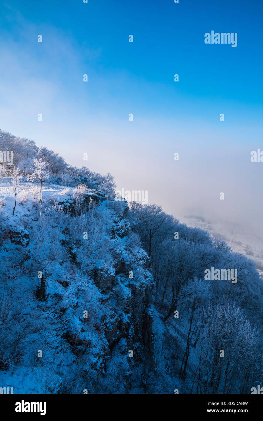 Deutschland, weiß schneebedeckte Felsen und Klippen am breitensteinberg Nationalpark schwäbische alb Naturlandschaft mit Nebel im Winter früh morgens blau Stockfoto