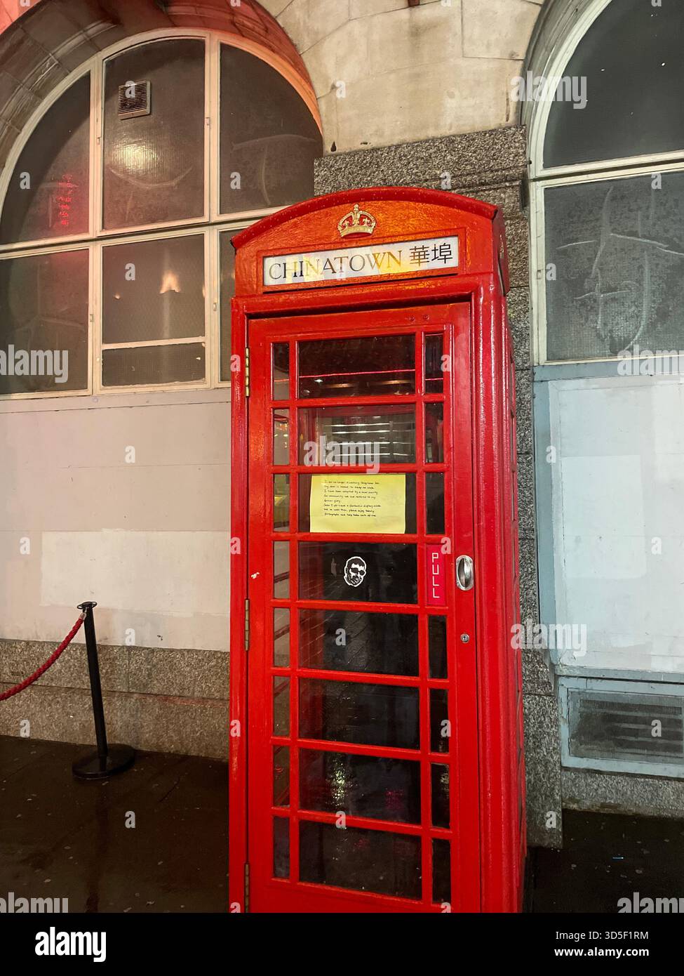 Traditionelle rote britische Telefonbox auf einer Londoner Straße, Symbol der britischen Kultur und des britischen Erbes. - Smartphone-aufgenommenes Stockfoto