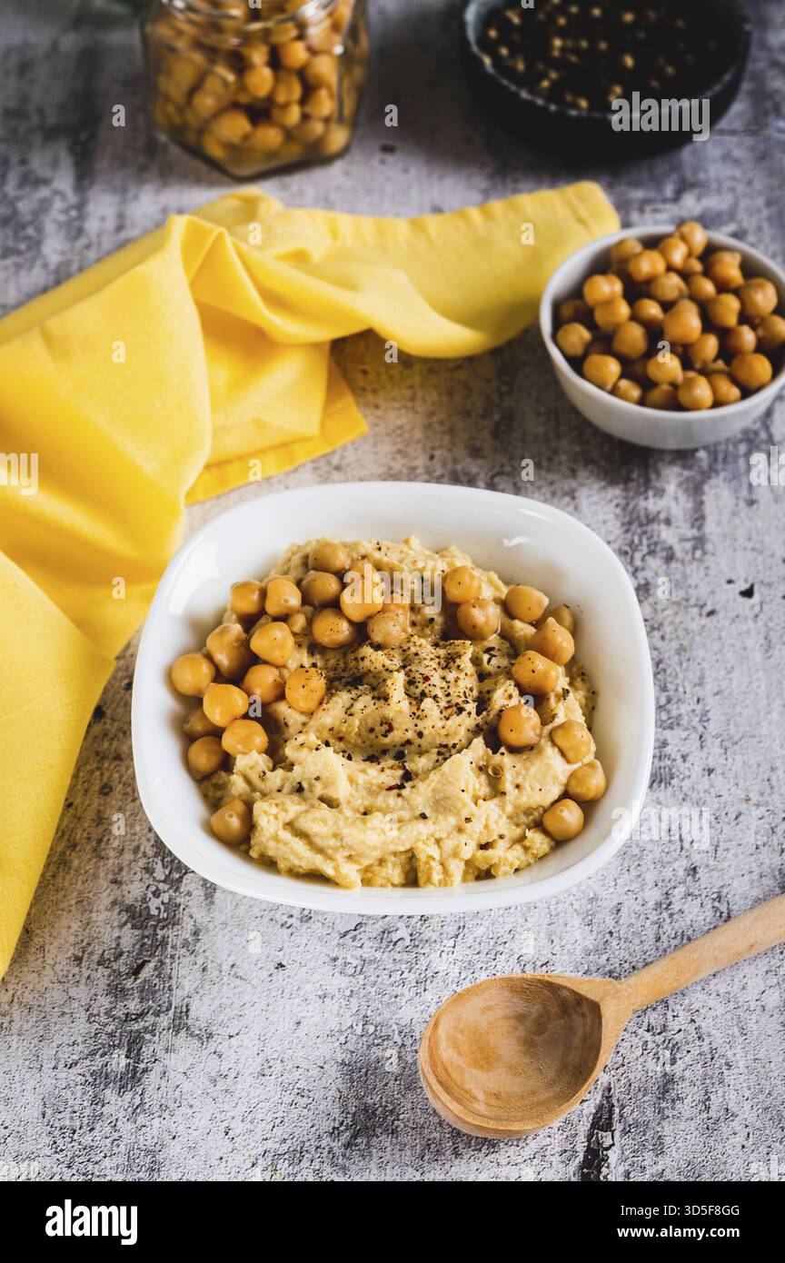 Vegetarischer würziger Kichererbsen-Hummus in einer Schüssel auf dem Tisch mit vertikaler Sicht Stockfoto