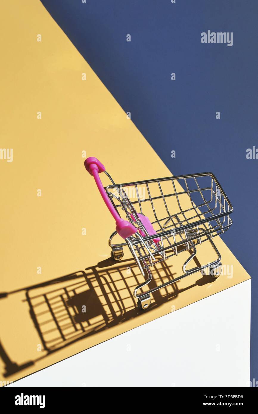 Shop Trolley auf gelb und blau hellen Hintergrund. Modernes Mall-Konzept. Isometrisches, trendiges Layout. Markt Warenkorb Trend Tapete. Supermarkt leerer Zugang Stockfoto