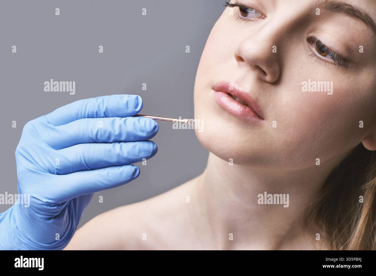 Schleifengerät für medizinische Konstruktion. Das Frauenhautverfahren. Kosmetische Produkte. Hände in Handschuhen. Schönheitsgesicht. Kosmetologische Gesichtsbehandlung. Gesundheitswesen Anti-AC Stockfoto