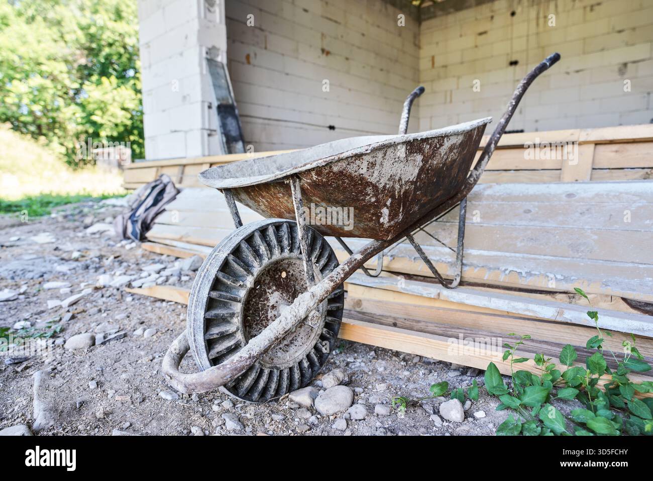 Alte leere Schubkarre auf der Baustelle des Hauses, Nahaufnahme Stockfoto