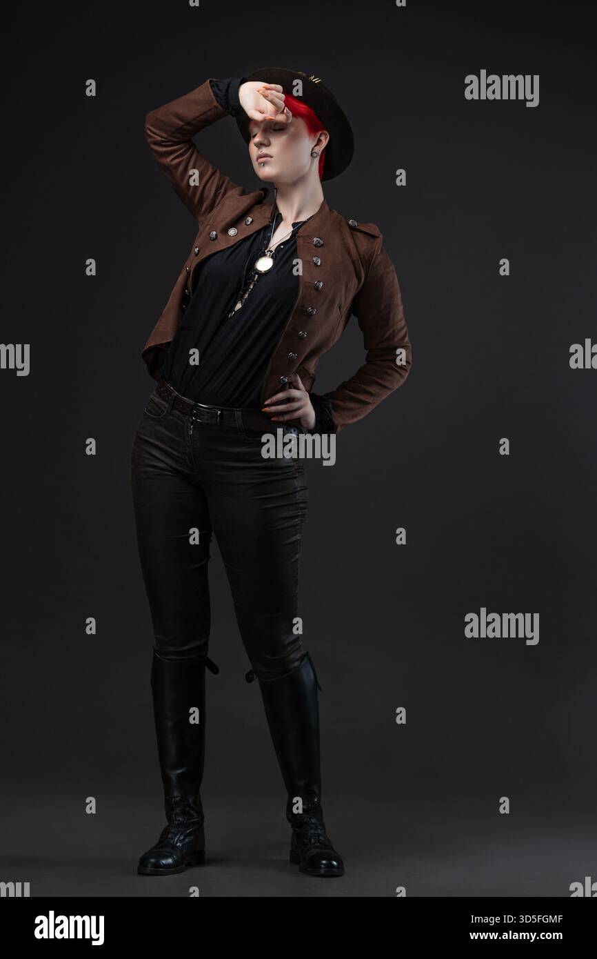 Rothaarige Dame im Steampunk-Outfit mit Bowler-Hut und Schutzbrille Stockfoto