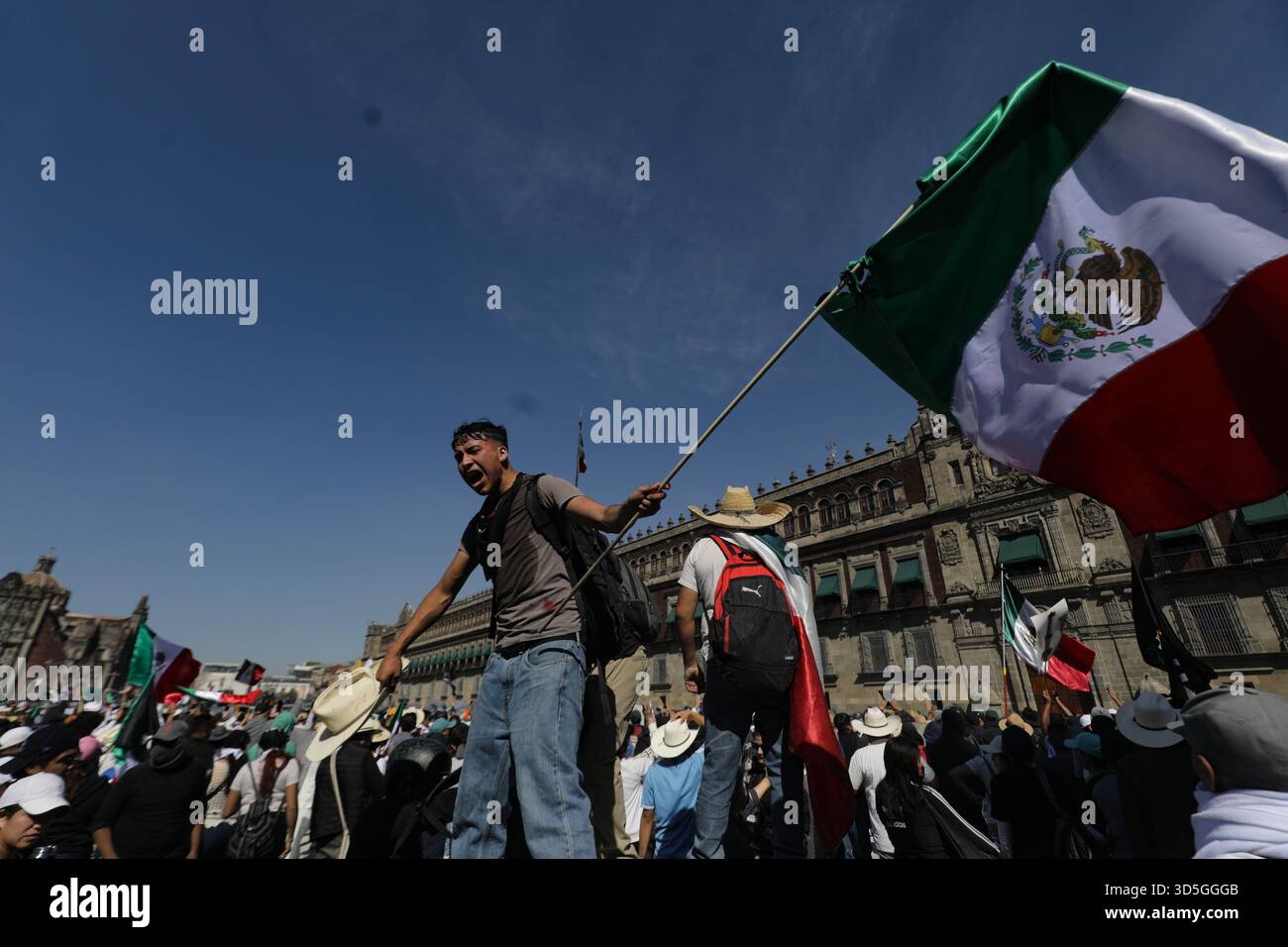 Mexiko-Stadt, Mexiko. November 2025. Während der Demonstration der „Gen Z“ auf dem Hauptplatz Zocalo gegen die mexikanische Regierung nach der Ermordung des Bürgermeisters von Uruapan Carlos Manzola schwingt eine Person eine mexikanische Flagge, während Mexikos Präsidentin Claudia Sheinbaum in den letzten Tagen die Legitimität der Bewegung in Frage gestellt hat. Am 15. November 2025 in Mexiko-Stadt. (Foto: Ian Robles/Eyepix Group/SIPA USA) Credit: SIPA USA/Alamy Live News Stockfoto