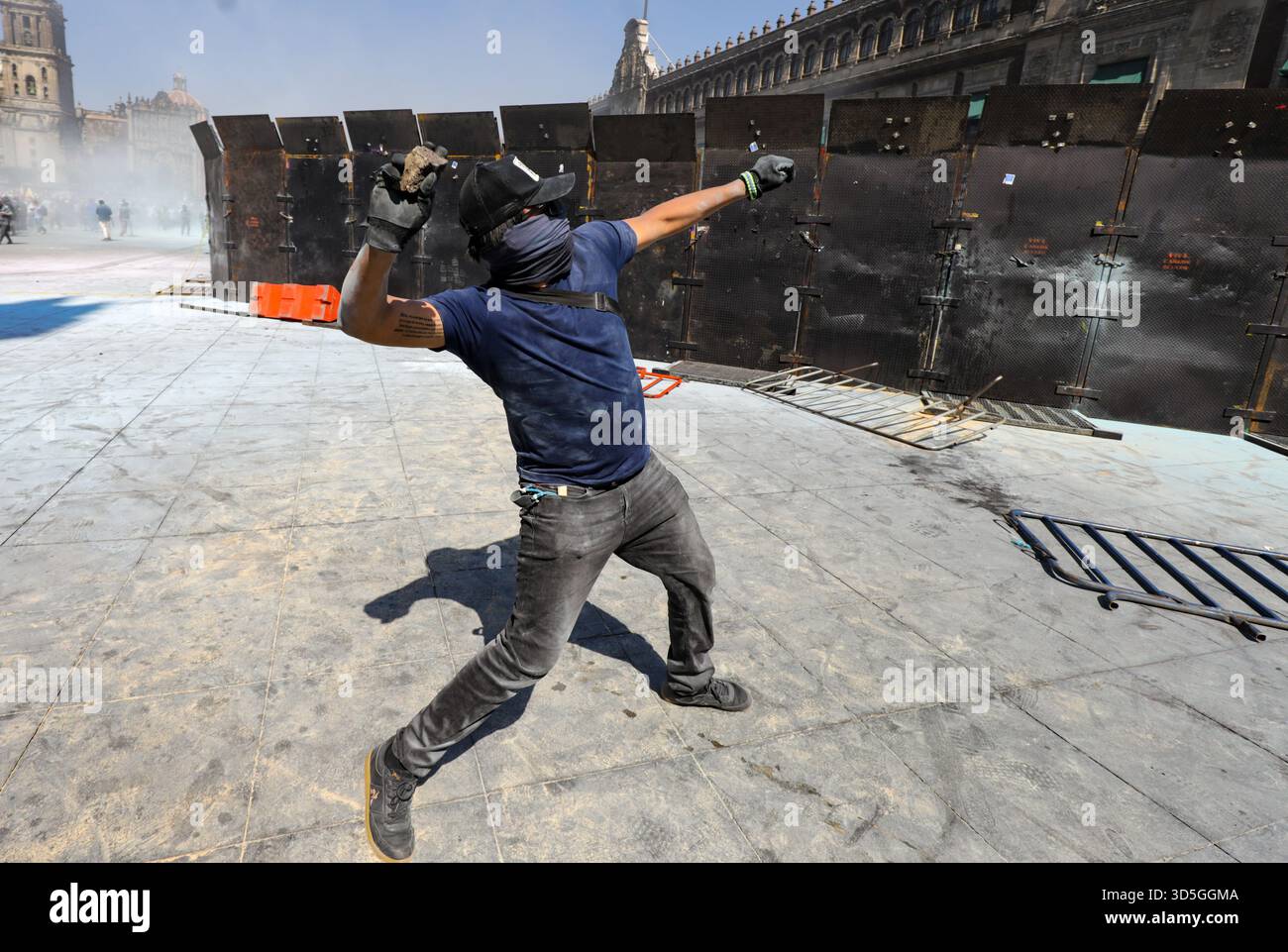 Mexiko-Stadt, Mexiko. November 2025. Eine Person wirft während der Demonstration „Gen Z“ auf dem Hauptplatz Zocalo einen Stein gegen die mexikanische Regierung nach dem Mord an dem uruapanischen Bürgermeister Carlos Manzola, während Mexikos Präsidentin Claudia Sheinbaum in den letzten Tagen die Legitimität der Bewegung in Frage gestellt hat. Am 15. November 2025 in Mexiko-Stadt. (Foto: Ian Robles/Eyepix Group/SIPA USA) Credit: SIPA USA/Alamy Live News Stockfoto