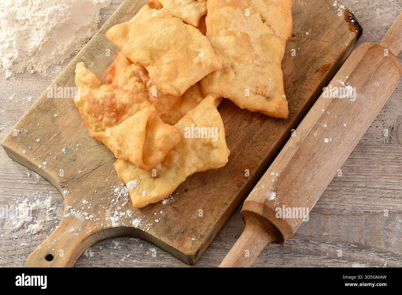 Hausgemachter Blätterteig auf einem hölzernen Schneidebrett mit Mehl und einer Nudelnadel. Traditionelle Weihnachtszubereitung Stockfoto
