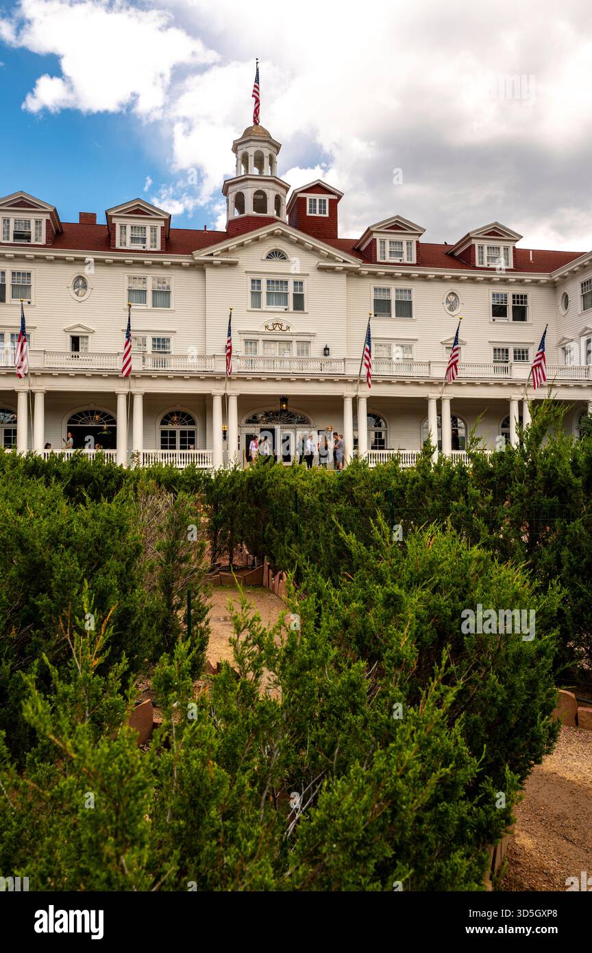 Historisches White Mansion Hotel mit Flaggen, Veranda und üppiger grüner Fassade am Eingang Stockfoto