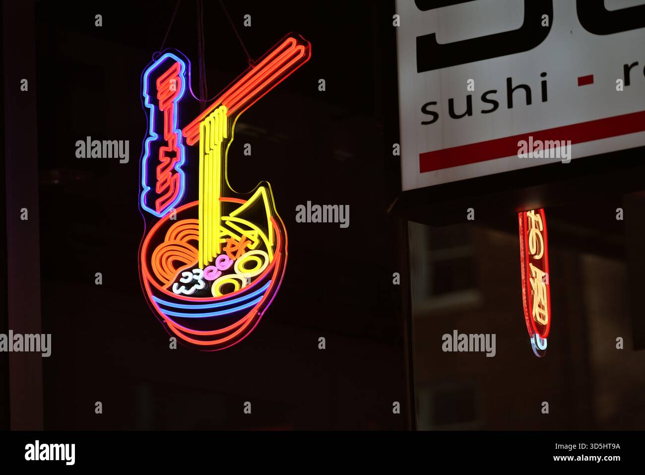 Schild mit elektrischer Nudelschüssel vor einem Sushi-Restaurant Stockfoto