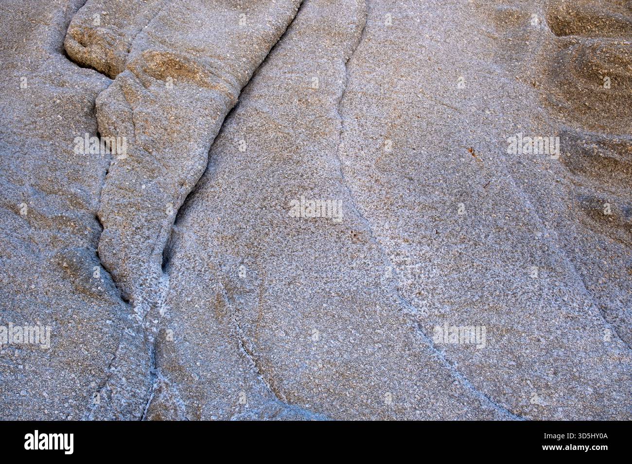 Verwitterter Granitstein bei sanftem Tageslicht mit feinen Rissen und feinen Details Stockfoto